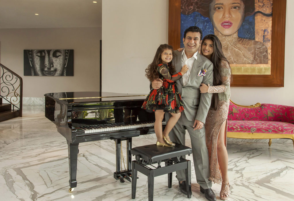 A FAMILY PORTRAIT OF SUNIL DARA WITH HIS DAUGHTERS AT HIS HOME.